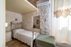 een slaapkamer met 2 bedden en een stenen muur bij Casale San Giusi by Perle di Puglia in San Michele Salentino