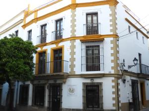 een wit gebouw met zwarte ramen en balkons bij Apartamentos Consistorio Live in Jerez de la Frontera