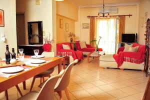 un soggiorno con mobili rossi, tavolo e sedie di Casa center in Chania a Chania