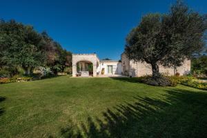 een huis met een grote tuin met bomen en gras bij Casale San Giusi by Perle di Puglia in San Michele Salentino