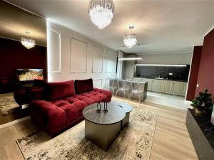 a living room with a red couch and a table at STUDIO 92- URBAN PLAZA in Braşov