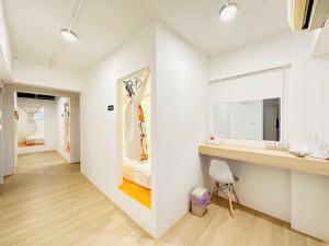 a room with a white wall with a painting on the wall at 三狗3dogs hostel in Chiang Mai