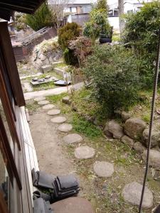 un jardín con un sendero con rocas y una casa en Japanese old house en Takatsuki