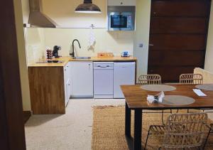 a kitchen with a sink and a table with chairs at Casa do Espigueiro in Chaves