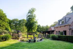 a garden with a fountain in front of a house at Londons Cottage in Hilversum