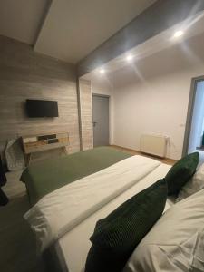 a bedroom with a large bed and a flat screen tv at Marisah Residence #3 in Otopeni