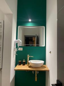 a bathroom with a sink and a green wall at Marisah Residence #3 in Otopeni