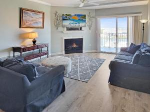 a living room with two couches and a fireplace at Mariners Watch 304 - Luxury Bayview Condo in Ocean City
