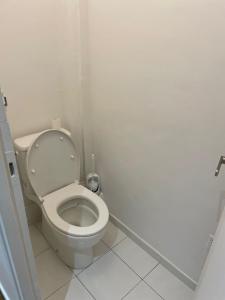 a white bathroom with a toilet in a stall at 5 people/Paris-CDG/France Stadium in Bagnolet