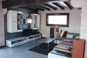 ein Wohnzimmer mit einem Sofa und einem TV in der Unterkunft Chez Sof et Flo in Bugny