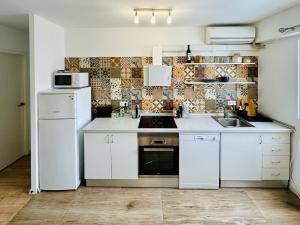 バレンシアにあるHarbor Apartments Valenciaのキッチン(白いキャビネット、白い冷蔵庫付)