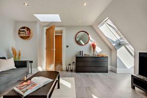 a living room with a couch and a mirror at The Nook in Burford