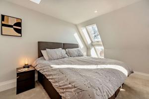 a bedroom with a bed with a nightstand and a window at The Nook in Burford