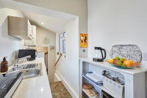 a kitchen with a sink and a bowl of fruit on a shelf at Host & Stay - Millers Coach House in Hexham