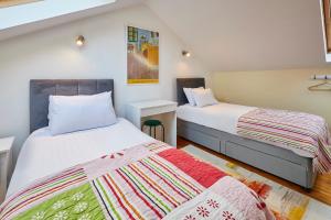 two beds in a small room with two beds at Host & Stay - Millers Coach House in Hexham