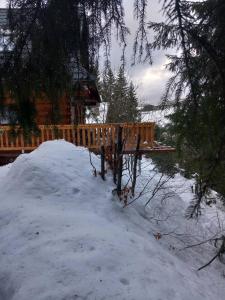 a bench in the snow in front of a cabin at Drevenica Čertovica in Liptovská Sielnica