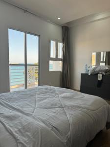 um quarto com uma cama grande e 2 janelas em Muttrah Souq and Sea View em Mascate