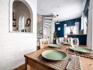a dining room with a table with green plates and wine glasses at Pass the Keys Modern central flat with character features in Exeter