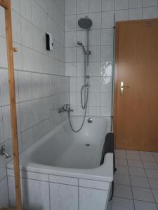 a bathroom with a bath tub with a shower at NEU - Familienfreundlich - Für bis zu 6 Personen in Oberhof
