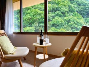 uma garrafa de vinho sentada numa mesa ao lado de uma janela em Yuze Hotel em Kazuno