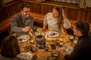 オーバータウエルンにあるOBERTAUERN PLACESHOTEL by Valamarの食卓に座って食べる人々