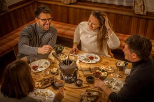 Eine Gruppe von Menschen, die an einem Tisch sitzen und Essen essen. in der Unterkunft OBERTAUERN PLACESHOTEL by Valamar in Obertauern