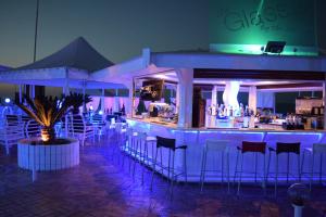 a bar with bar stools in a restaurant at night at Pola Costa Beach Hotel Apts - Adults Only in Protaras