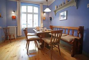 a dining room with a table and chairs and a window at Historisches Altstadthaus St Georgen - ABC347 in Wismar