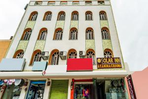 a building with a red sign in front of it at Solar Inn in Tirupati