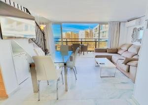 マルベーリャにあるSkol 508 West Facing Duplex Apartment with Amazing Sea Viewsのリビングルーム(テーブル、ソファ付)