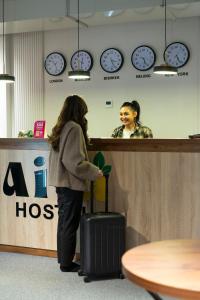 una donna in piedi al bancone della reception con di Aiva Hostel a Bishkek