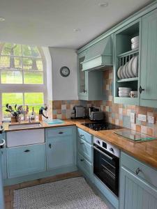 a kitchen with blue cabinets and a sink and a window at The Old Schoolhouse in Morar