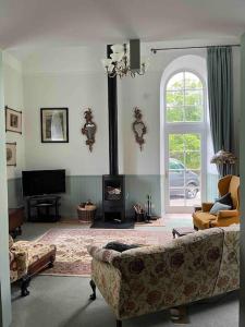 sala de estar con sofá y chimenea en The Old Schoolhouse, en Morar