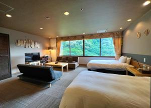 a hotel room with two beds and a television at Yuze Hotel in Kazuno