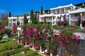 een groot wit gebouw met roze bloemen erop bij Sianji Well-Being Resort in Turgutreis