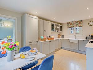 a kitchen with blue chairs and a table with a tablektop at 2 Bed in Pencombe 27478 in Pencombe