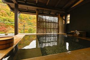 einen Pool mit Wasser in einem Zimmer mit Fenster in der Unterkunft Yuze Hotel in Kazuno