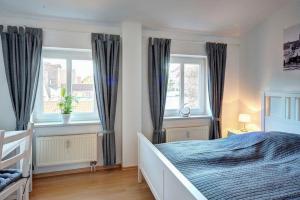 een slaapkamer met een bed en 2 ramen bij Traumfänger in Wismar