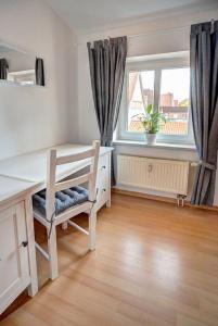 einen Schreibtisch und einen Stuhl in einem Zimmer mit Fenster in der Unterkunft Traumfänger in Wismar