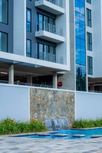 um edifício de apartamentos alto com uma parede de retenção em frente em Outstanding 2BR Sandton with a View em Joanesburgo