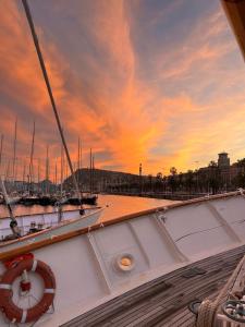 un bateau amarré dans un port avec un coucher de soleil dans l'établissement Southern Cross, à Barcelone