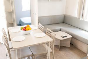 a room with a table with a bowl of fruit on it at Càmping Bellsol in Pineda de Mar
