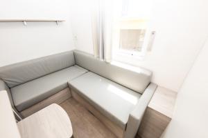 a white couch in a room with a window at Càmping Bellsol in Pineda de Mar