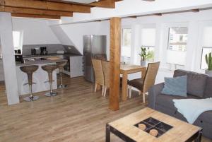 een woonkamer en een keuken met een bank en een tafel bij Sweet Home Wismar - ABC261 in Wismar