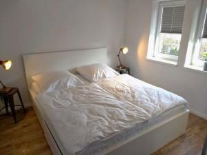a white bed in a bedroom with two windows at Sweet Home Wismar - ABC261 in Wismar