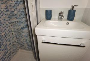 カターニアにあるLuxury Sisters House "Le Ancore"の白い洗面台とシャワー付きのバスルーム