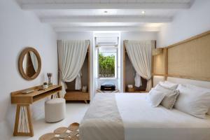sypialnia z łóżkiem, stołem i lustrem w obiekcie Villa Agia Thalassa Beachfront Luxury Villa Ampelas Paros w mieście Paros