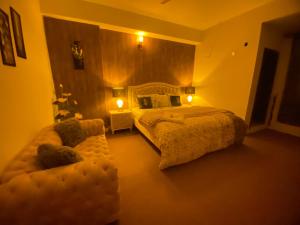 um quarto com uma cama grande e um sofá em Viceroy Royal Hotel Apartment Islamabad em Islamabad