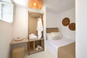 małą sypialnię z łóżkiem i lustrem w obiekcie Villa Agia Thalassa Beachfront Luxury Villa Ampelas Paros w mieście Paros +37 zdjęć