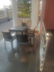 patio con tavolo e sedie sotto il portico di CRYSTAL SUITES ad Akure